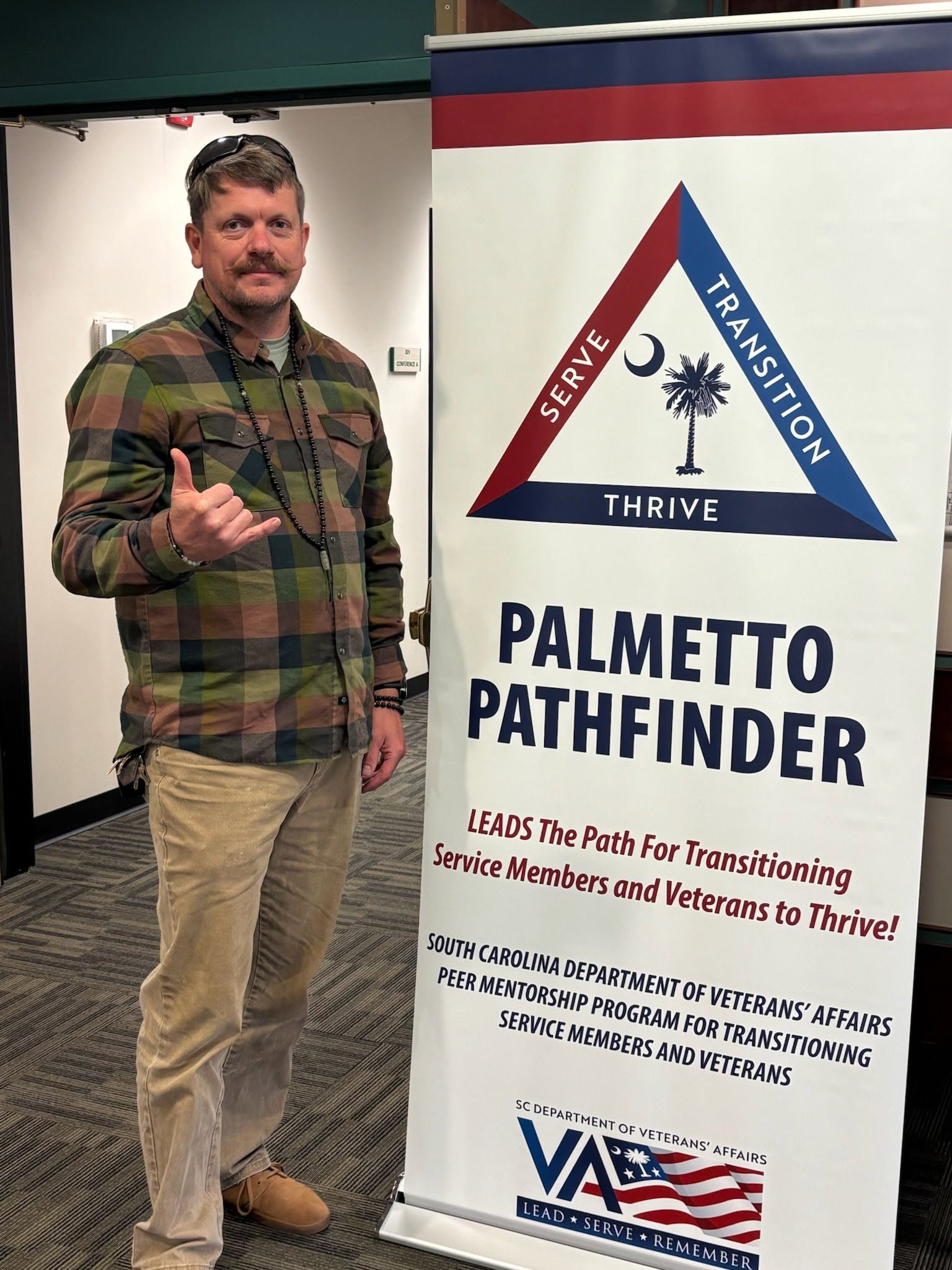Hendrick posing with Palmetto Pathfinder sign