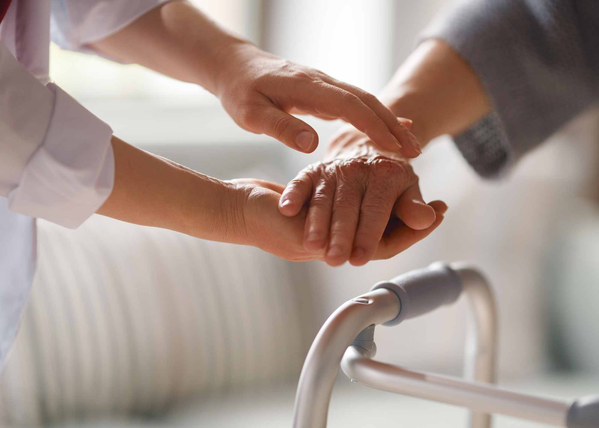 One woman holding another woman hand above a mobility aid