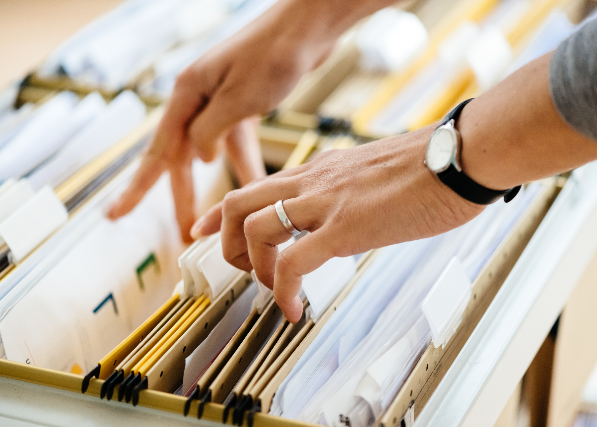 person fingering through files in a file cabinet