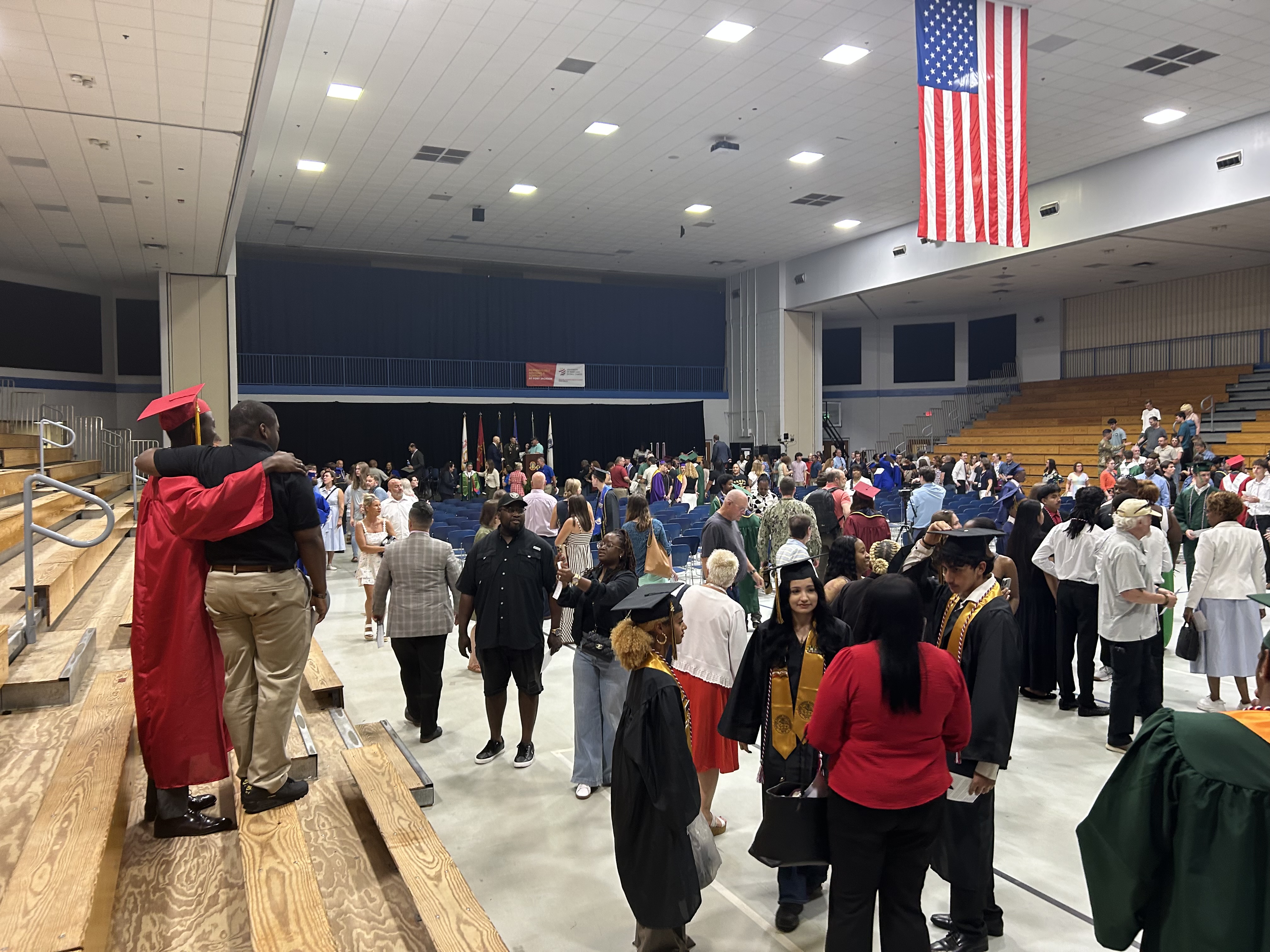 Image of crowd gathering with students following ceremony