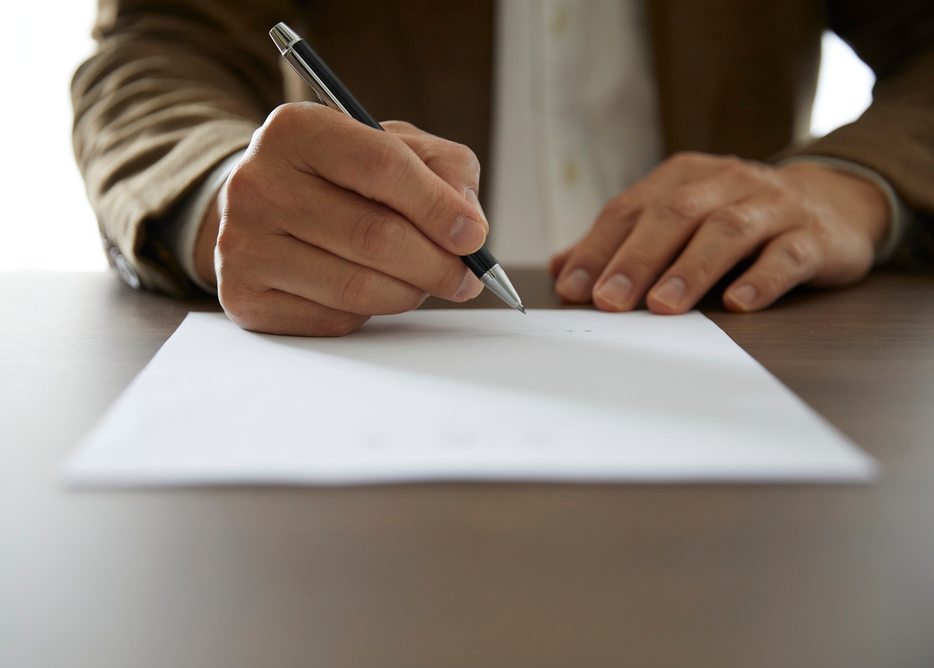 Man with pen in his hand signing a document