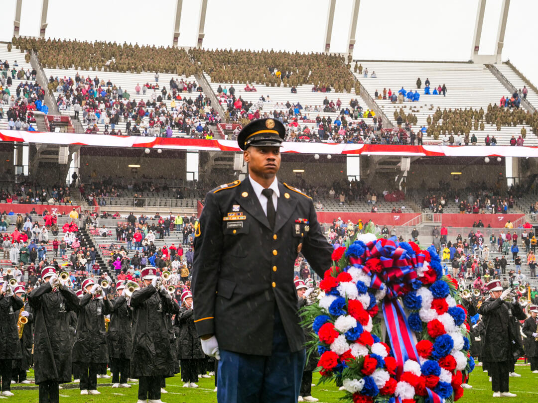 Soldier stands at attention behind a wreath during the University of South Carolina's Salute the Troops half-time show.